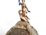 a gold clock with a statue on top of it