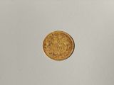 a close up of a gold coin on a white surface