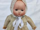 a small doll with a bonnet on it ' s head