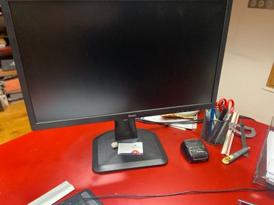 un bureau rouge sur lequel se trouvent un écran d'ordinateur et d'autres objets