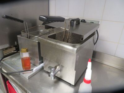 two deep fryers sitting on a counter in a kitchen