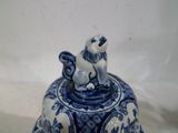 un chat bleu et blanc assis sur une cloche