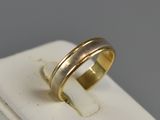 an image of a gold wedding ring on a white surface