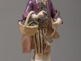 a figurine of a man with a basket on a table