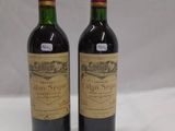 deux bouteilles de vin posées sur une table blanche