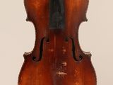un vieux violon posé sur une surface blanche