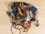 a pile of assorted jewelry on a wooden surface