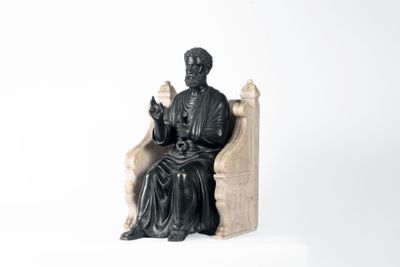 une statue représentant un homme assis sur une chaise