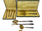 a set of silverware in a case on a white background
