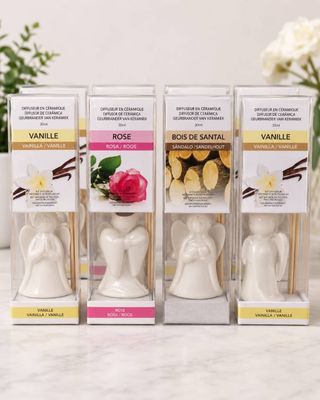 three white candles are sitting on a table next to a vase of flowers