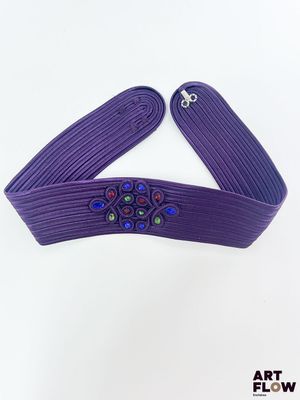 un gros plan sur une ceinture violette ornée de perles