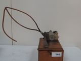 a small wooden box with a metal object on top of it