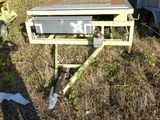 a man standing in a field next to a machine