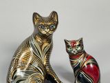 deux figurines de chats assis l'un à côté de l'autre