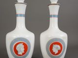 une paire de vases blancs ornés de motifs bleus et orange