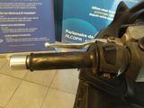 a close up of a motorcycle handle with a sign in the background