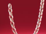 a close up of a silver chain on a red background