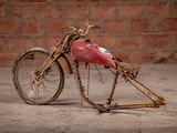 an old motorcycle that is sitting in front of a brick wall