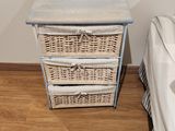 une commode en osier dans un coin d'une chambre