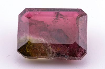 un gros plan d'une tourmaline rose posée sur une surface blanche