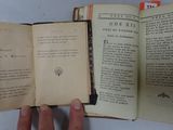 someone is holding an open book in their hands on a table