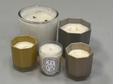 Plusieurs bougies sont disposées en rangée sur une surface grise