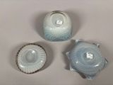 three pieces of pottery sitting on a table