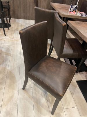 tables and chairs in a restaurant with wooden walls and tile flooring