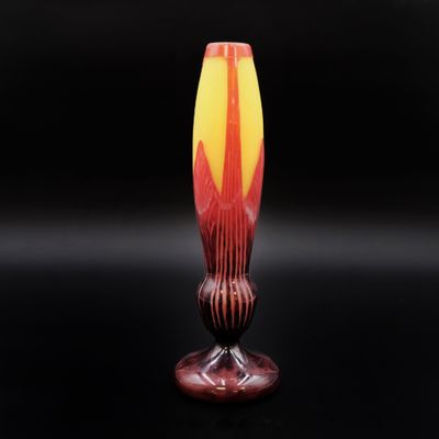 un vase orange et jaune posé sur une table noire
