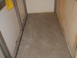 a small room with a metal door and a metal floor
