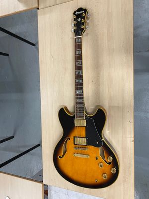 une guitare accrochée au mur dans une pièce équipée d'étagères