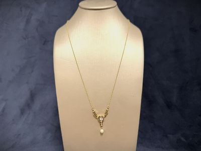 a white mannequin with a gold necklace on it