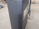 a black oven sitting on top of a pallet in a warehouse