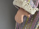 a close up of a doll ' s hand holding a doll ' s hand