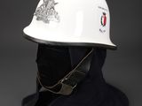 white hard hat on a black background with a red and white emblem