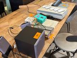 il y a beaucoup d'appareils électroniques sur la table dans la pièce