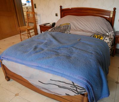 un lit recouvert d'une couverture bleue