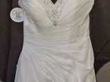 wedding dress hanging on a hanger in a bridal shop