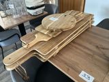 Plusieurs planches à découper en bois sont empilées sur une table