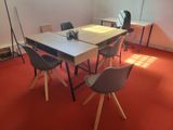 a table and chairs in a room with a red carpet