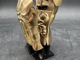 gold sculpture of a horse ' s head on a black stand