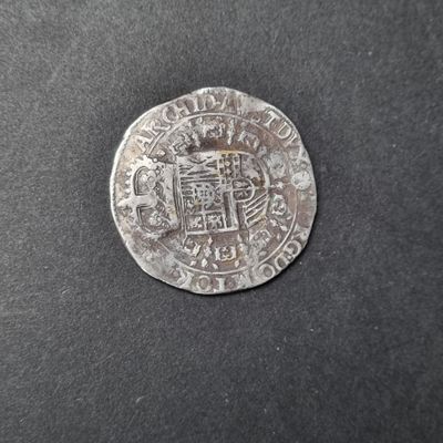 un gros plan d'une pièce d'argent sur laquelle figure un blason