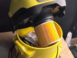 le seau jaune, rempli de produits d'entretien, est posé sur une table en bois