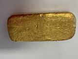 un gros plan d'un morceau d'or sur une surface blanche