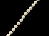 un gros plan d'un collier de perles sur fond noir