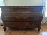 une commode en bois avec de nombreux tiroirs dans une pièce