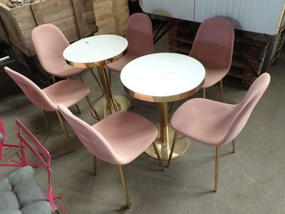 plusieurs chaises et une table dans une pièce avec beaucoup de meubles
