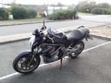 a black motorcycle parked in a parking lot next to a street