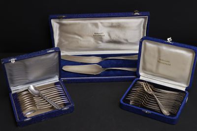 three pieces of silverware in a blue case on a black surface