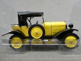 une maquette jaune de voiture exposée dans une vitrine